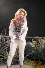an attractive middle-aged blonde woman topless in a white shirt with lavender. 