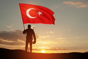 Silhouette of soldier with Turkey flag against the sunrise or sunset. Concept of crisis of war and...