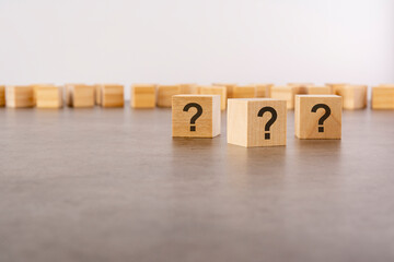 front view on many wood cubes with question marks. many question arising concept