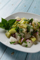 Honeydew melon salad with cucumber and mint, served on a plate.