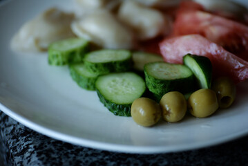 delicious hearty healthy breakfast in ukraine store-bought dumplings chopped red juicy tomatoes green cucumbers and juicy olives
