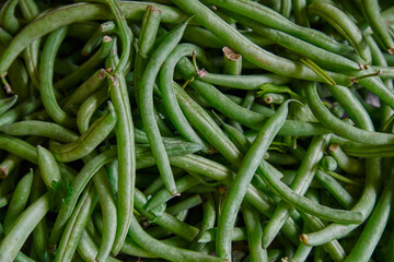 Green beans placed on a shelf for sale in a market