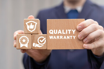 Quality warranty concept. Businessman holding wooden blocks with quality warranty concept. Advertising product and service quality commitment.