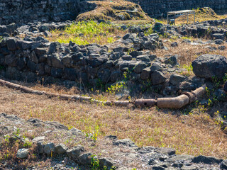 Fototapeta na wymiar Ruin of an old castle. Remains of civilization. Fortress in Georgia. The city of ancient stone masonry. Site of archaeological finds. Ancient plumbing. Remains of clay pipes