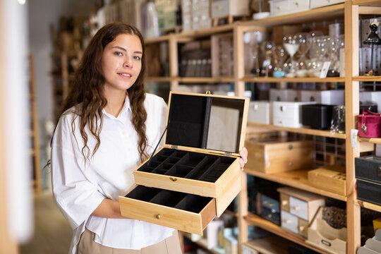 Female shopper chooses wooden box in furniture shop