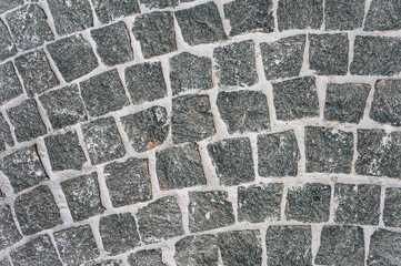 Background, texture of gray vintage square tiles, paving stones, stone on the street in the city. Photo, top view.