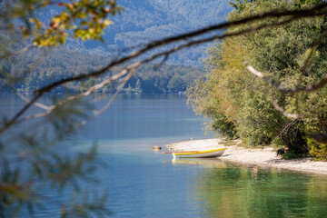 Selective blur on a rowing boat of a shore beach of Lake Bohinj, called bohinjsko jezero, on a sunny summer afternoon. Bohinj lake is a major landmark of Julian Alps mountain chain in Slovenia, Europe
