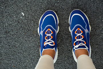 Woman's legs in blue sneakers outdoor, close up. Modern sport fashion concept.