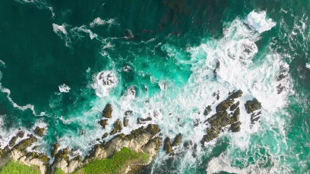Scenic dangerous sea waves on cinematic rocky beach in Monterey, 17 miles scenic drive, California USA. Aerial top view 4k footage by drone of ocean blue waves break on high cliff of rocky mountain