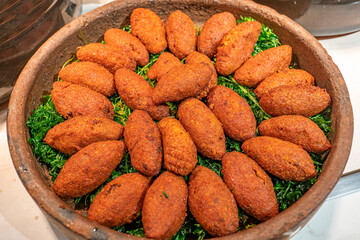 The core ingredients of İçli köfte  (Stuffed Meatballs) are bulgur, minced onions, walnuts, finely ground lean beef, and spices.