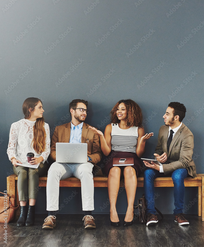 Poster happy business people working with technology, talking while sitting in a row against a grey backgro