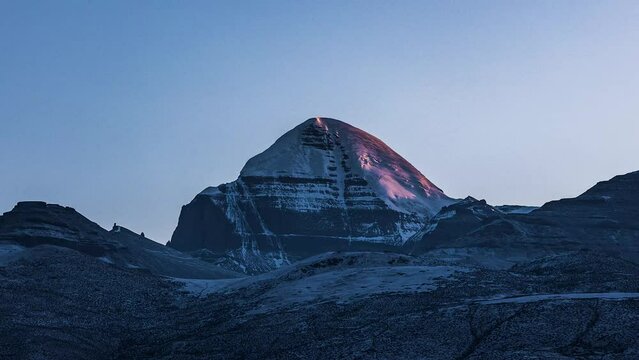 Time-lapse of cloudless sunrise sky over snowcap mountains