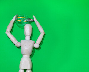 Mannequin Wood Figure carrying an incandescent light bulb. New idea concept. green screen