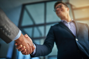 A professional handshake after a successful group collaboration meeting after in a modern corporate...
