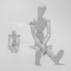 sad wooden mannequins. two mannequins father and son. white background