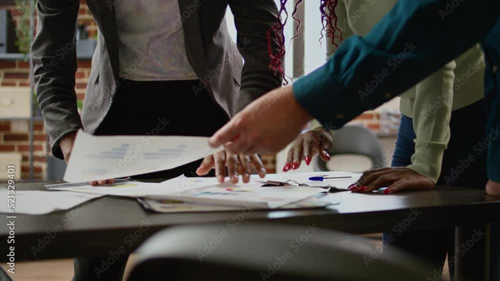 Poster diverse team of coworkers looking at business charts on documents, analyzing research information an