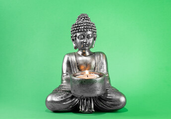 buddha statue with lit candle. green screen