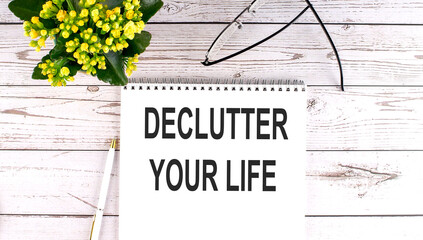 DECLUTTER YOUR LIFE text concept write on notebook on wooden background