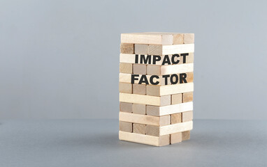 IMPACT FACTOR text on a wooden block , grey background