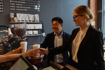 Beautiful Couple Ordering Coffee Together In Cafe. Happy Young Man And Gorgeous Smiling Woman Standing at the Bar Counter In Coffee Shop. High Quality Image