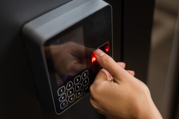 A woman opens the door with her fingerprint. Modern keyless entry lock. 