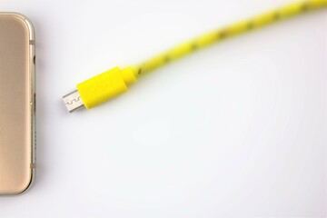 Smartphone charging. Battery charging cable and smartphone on a white isolated background.