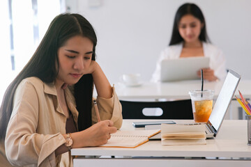 Young college student using computer and mobile device studying online.