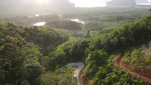 Aerial view of countryside and car on road pan to beautiful view of smed nang she phang nga