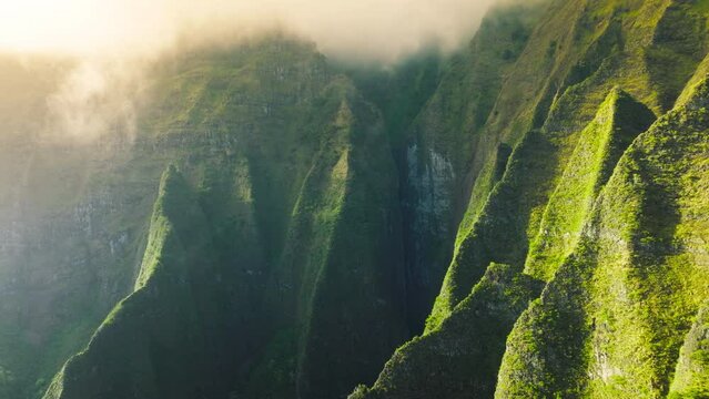 Amazing impressive green steep walls of Jurassic park landscape in Napali coast park on Kauai island Hawaii state nature park, USA tourism background footage. Morning clouds in golden sunrise sun rays