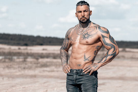 Sexy portrait of muscular handsome topless male model at the beach