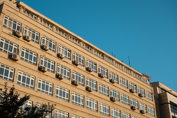 Naklejka premium Diyarbakır. Turkey. Government building in Diyarbakr. Sun light reflection on facade of wall. Many air conditioners hanging on wall and window.