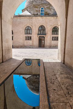 07.10.2022. Mardin. Turkey. Facade view of mosque in Mardin, Erkulu mosque, local name Erkulu cami, reflection of facace of mosque on pond. 
