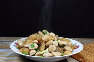 Traditional fried fresh pork skin with pork ball serving on the plate. Famous ancient menu in Chinese restaurant.