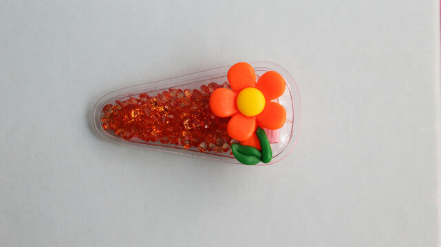 Accesorio para pelo con flor anaranjada y piedritas.