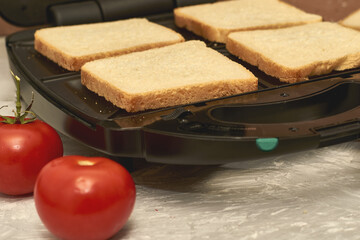 sandwich maker cheese sausage and bread on the table