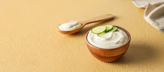 Bowl with tasty sour cream on color background with space for text