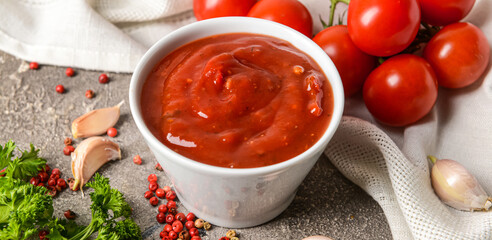 Bowl of organic tomato sauce on grunge background