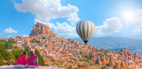 Hot air balloon flying over spectacular Cappadocia - Japanese girls watching hot air balloon at the...
