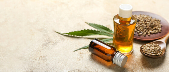 Bottles of hemp oil with seeds on grunge background