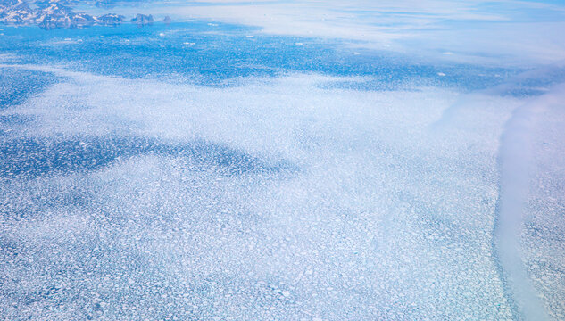 View From Airplane Of Melting Polar Ice Cap And Snowy Mountains - Greenland