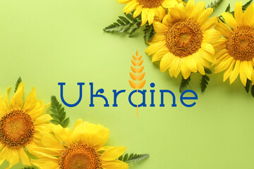 Beautiful sunflowers and word UKRAINE on green background