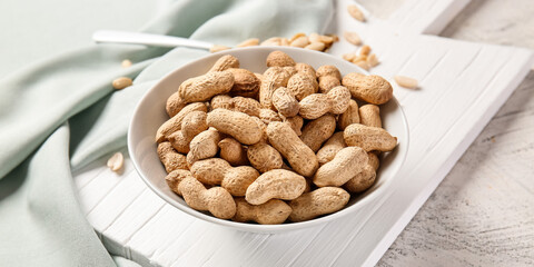 Bowl with peanuts on table, closeup