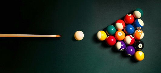 Pyramid made of billiard balls and cue on table, top view