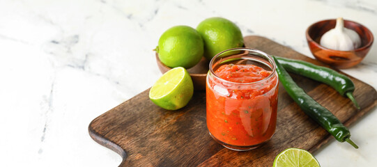 Jar of tasty salsa sauce on light background - obrazy, fototapety, plakaty