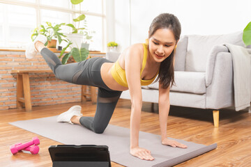 Plank fitness, beautiful asian young woman in sportswear, using tablet for online training strength...