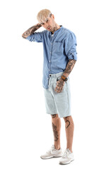 Young tattooed man in denim shirt on white background