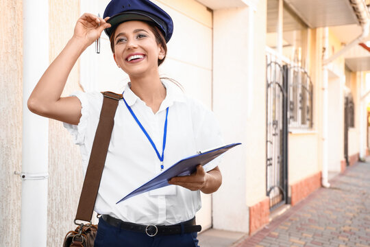 Young Postwoman With Clipboard Outdoors