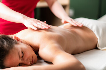 Fototapeta na wymiar Massage for stress and tension relief. Female massage therapist massaging a woman