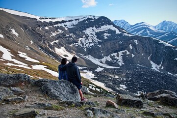 Mature couple sitting on the rock in the mountain