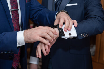helps groom to put on cufflinks close up